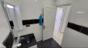 a bathroom with a sink and a washing machine at Al Hoceima Ajdir Maroc - Maison 5 chambres 10 personnes in Al Hoceïma