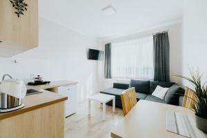 a kitchen and living room with a couch and a table at Willa Karol in Karwia