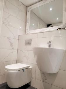 a white bathroom with a toilet and a mirror at Luxury Penthouse on Waterside Knaresborough in Knaresborough