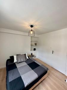1 dormitorio con 1 cama y luz colgante en Charmant T2 Cosy en plein centre ville, en Montluel