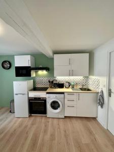 cocina con armarios blancos y lavadora en Charmant T2 Cosy en plein centre ville, en Montluel