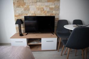 ein Wohnzimmer mit einem TV auf einem Tisch mit Stühlen in der Unterkunft Milmari Nlux 74 in Kopaonik