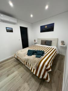 a bedroom with a bed with two blue towels on it at Casa da Margarida in Vila Nova de Foz Coa