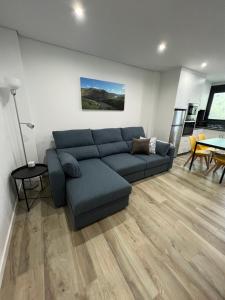 a living room with a blue couch and a table at Casa da Margarida in Vila Nova de Foz Coa