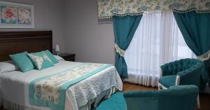 1 dormitorio con 1 cama y 2 sillas azules en Hotel Rarinco en Los Ángeles