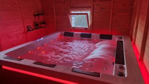 a hot tub in a room with red lights at Mare Nostrum Santo in Oia