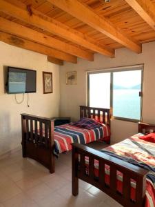 a bedroom with two beds and a flat screen tv at the best view in Valle de Bravo in Valle de Bravo
