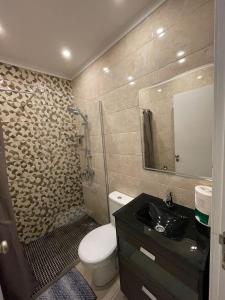 La salle de bains est pourvue de toilettes, d'un lavabo et d'un miroir. dans l'établissement Cantinho da Lena, à Sacavém