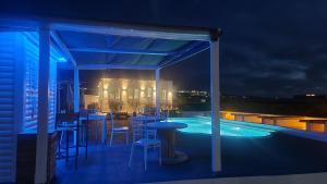 a patio with a bar and a swimming pool at night at Mare Nostrum Santo in Oia