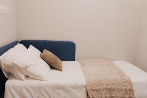 - un lit avec des draps et des oreillers blancs dans l'établissement Exclusive Apartment in Piazza Italia in Perugia, à Pérouse
