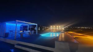 - une vue nocturne sur la piscine éclairée dans l'établissement Mare Nostrum Santo, à Oia