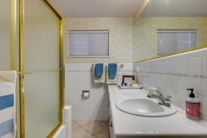 une salle de bain blanche avec un lavabo et un miroir dans l'établissement The Shorewood Lakeside Oasis, Pet-Friendly Getaway, à Marble Falls 40 autres photos