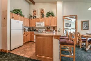 eine Küche mit Holzschränken und einem weißen Kühlschrank in der Unterkunft Hidden River Lodge 5995 in Keystone