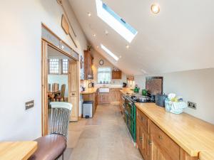 a large kitchen with wooden cabinets and a skylight at The Old Parish Hall in Quendon