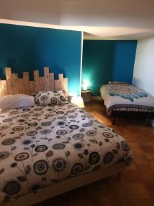 a bedroom with two beds and a blue wall at Gite troglodyte Les Iris in Villiers-sur-Loir