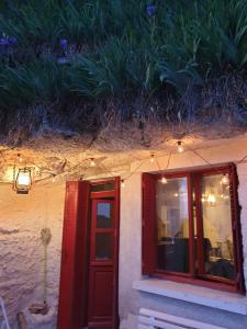 budynek z czerwonymi drzwiami i oknem z oświetleniem w obiekcie Gite troglodyte Les Iris w mieście Villiers-sur-Loir