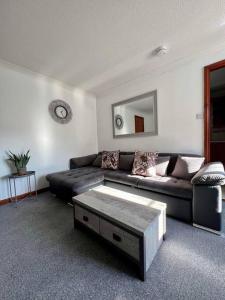 a living room with a couch and a coffee table at Apartment with parking, close to the Raigmore hospital in Inverness
