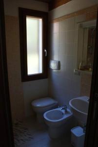 baño con aseo y lavabo y ventana en Villa Ludi en Maladroscia