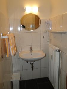 a white bathroom with a sink and a mirror at Pension Jahnkes Gasthaus in Todesfelde +38 photos