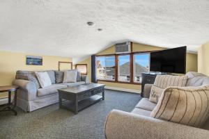 a living room with two couches and a flat screen tv at Abellona Inn & Suites in Old Orchard Beach