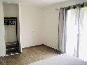 an empty room with a bed and a window at U Primu Appartement spacieux au calme Aléria in Aléria