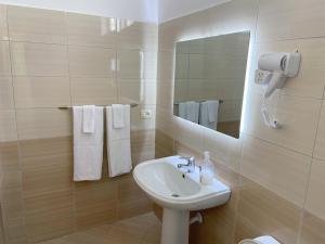 W łazience znajduje się umywalka, lustro i ręczniki. w obiekcie Guesthouse Niko w mieście Berat