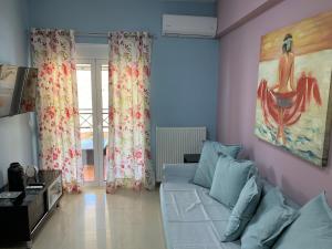 a living room with a couch and a painting on the wall at Christi Apartments B in Kokkini Khanion