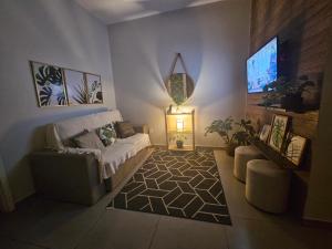 a living room with a couch and a tv at CASA_ESTRELA in Angra dos Reis