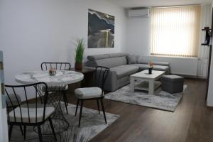 a living room with a couch and a table and chairs at Royal City Apartments in Jajce