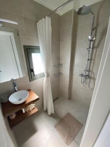 y baño con ducha y lavamanos. en Horizon Villa Mani - Seaview Family Friendly House, en Stoupa