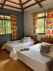 1 dormitorio con 2 camas en una habitación con ventanas en Andalucia, en Villavicencio
