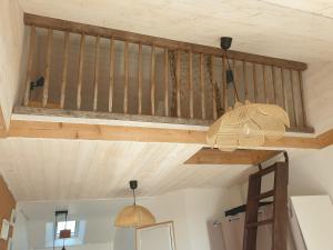 um tecto com vigas de madeira e duas luzes em Gîte Atypique avec jacuzzi em Hillion