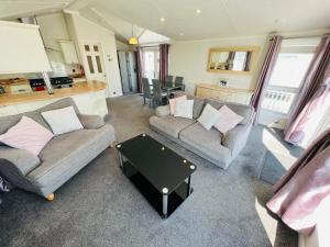 a living room with two couches and a table at 2 Bedroom Lodge TH35, Nodes Point, St Helens, Isle of Wight in Saint Helens