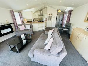 a living room with a couch and a kitchen at 2 Bedroom Lodge TH35, Nodes Point, St Helens, Isle of Wight in Saint Helens