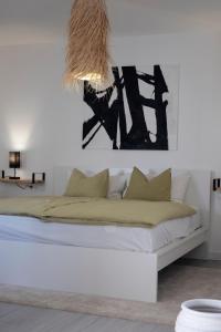 a white bedroom with a bed with a chandelier at Vulcano View at Casilla de Costa in La Oliva