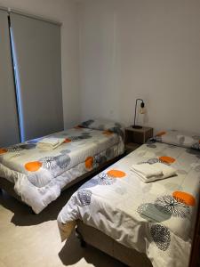 盧漢德庫約的住宿－Departamento Amoblado MorenoPark 683，两张睡床彼此相邻,位于一个房间里