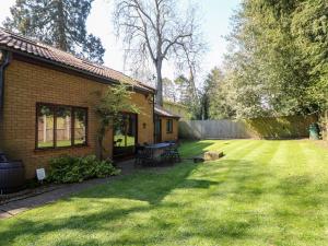 a yard with a brick house and a fence at Amberleigh in Oakham