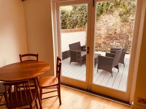 Habitación con puerta de patio con mesa y sillas en Abbey Gardens Cottage, en Bury Saint Edmunds