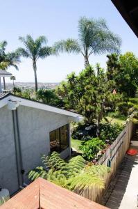 卡爾斯巴德的住宿－Casa La Costa Casita-30 days minimum，享有棕榈树和围栏的房子的景色