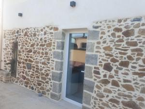 uma parede de pedra com uma janela num edifício em Gîte Atypique avec jacuzzi em Hillion