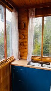 a kitchen with a window and a blue counter at Chata Jedovnice in Jedovnice