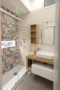 La salle de bains est pourvue d'une douche en verre et d'un lavabo. dans l'établissement Napolitan Pop House, à Naples