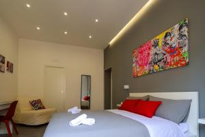 - une chambre avec un grand lit blanc et des oreillers rouges dans l'établissement Napolitan Pop House, à Naples