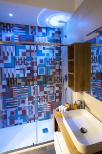 La salle de bains est pourvue d'un lavabo et d'un mur en mosaïque. dans l'établissement Napolitan Pop House, à Naples