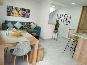 a living room with a blue couch and a table at Apto Nuevo, Tranquilo,Bonito,5 min Plaza Principal in Guatapé +17 photos