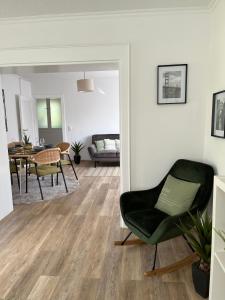 a living room with a chair and a dining room at Korbstadt-Villa Rattan-Design mit Balkon, Garten, Arbeitsplatz, Küche in Lichtenfels
