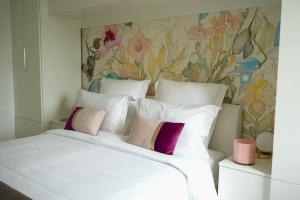 a bedroom with a large white bed with a floral wallpaper at Le Saint Val 004, Appart. neuf, jardin, parking in Saint-Valery-sur-Somme