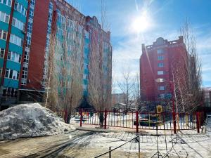 ogrodzenie przed wysokimi budynkami w obiekcie Элитная квартира возле гипермаркета Дины w mieście Aktobe