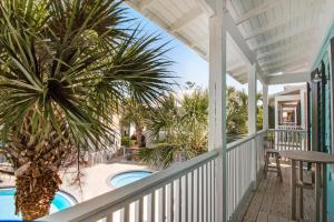 a porch with a palm tree and a swimming pool at Bungalows at Seagrove 135 - MerSea in Seagrove Beach