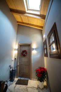 a hallway with a door with a wreath and red flowers at Casacaldametsovo in Metsovo